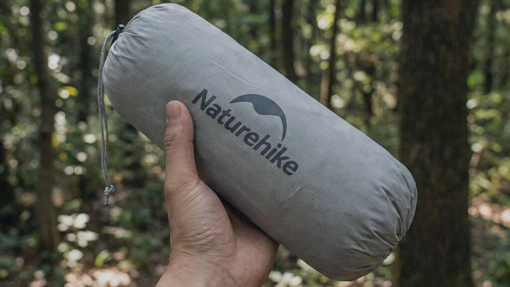 Hand holding the small packed bag of the Cloud Up 1 tent.