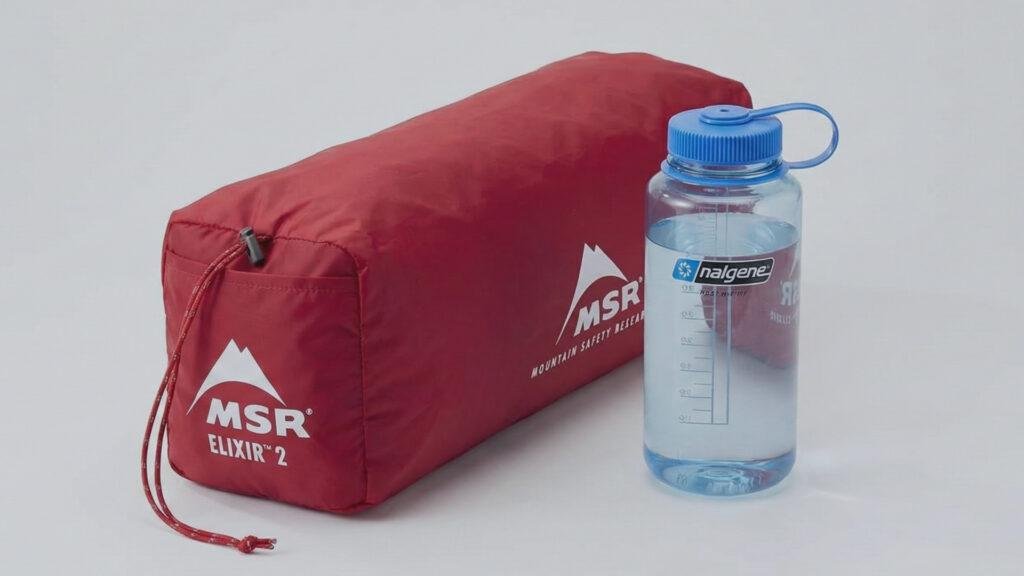 Packed MSR Elixir 2 tent next to a water bottle for size comparison.