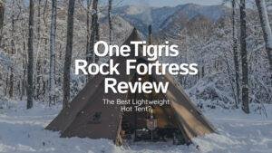 OneTigris Rock Fortress hot tent pitched in a snowy forest with a wood stove chimney smoking.