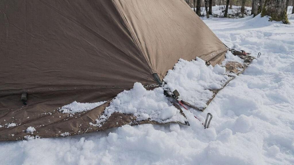 Snow skirts on the OneTigris Rock Fortress piled with snow to prevent drafts.