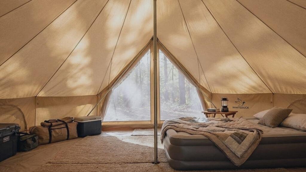 Spacious interior of the White Duck Regatta set up for glamping with a bed and stove.