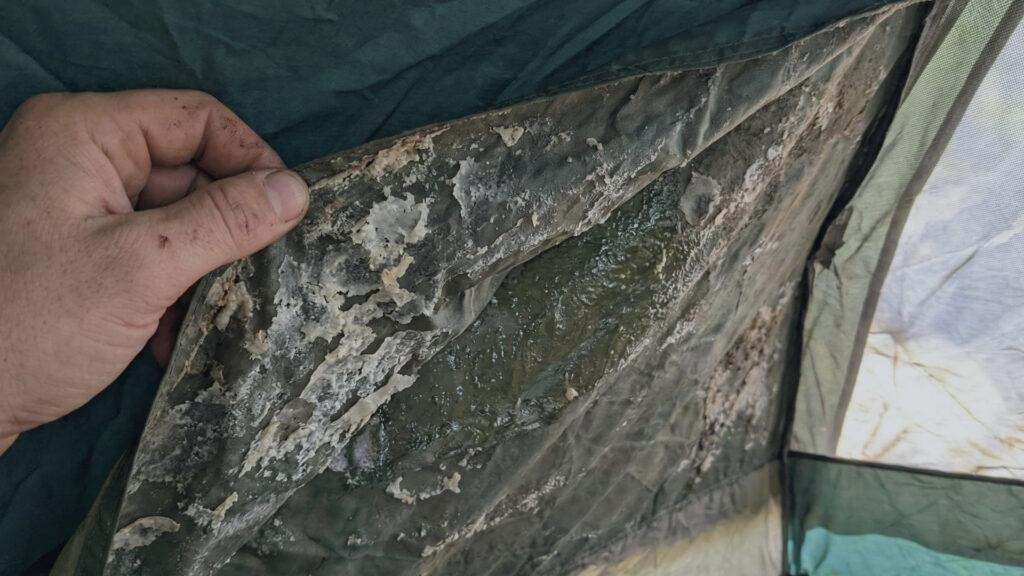 Evidence of hydrolysis on a tent fly showing flaking and sticky polyurethane coating.