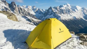 Black Diamond Eldorado yellow mountaineering tent pitched in snow on a high altitude ridge.