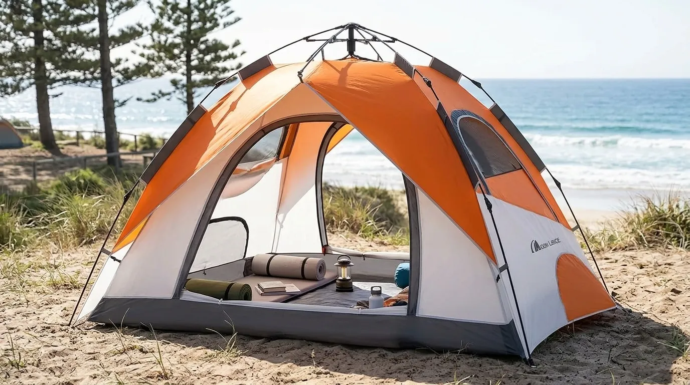 An orange Moon Lence pop up tent with all windows open for maximum ventilation at a beach campsite.