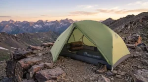A Sea to Summit Telos TR2 bikepacking tent set up on a rocky ridge at twilight.