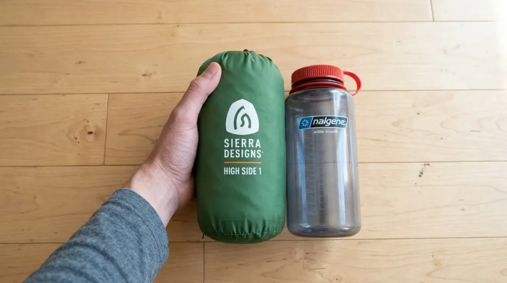 The Sierra Designs High Side 1 tent bag shown next to a water bottle for size comparison.