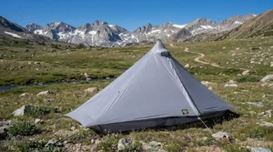 A Six Moon Designs Lunar Solo trekking pole tent pitched in a scenic mountain meadow.