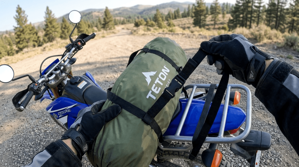 A TETON Sports Vista Quick Tent being strapped to the rear rack of a motorcycle for a camping trip.