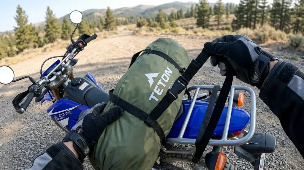 A TETON Sports Vista Quick Tent being strapped to the rear rack of a motorcycle for a camping trip.