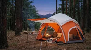 A white Vidalido automatic teepee tent set up in a scenic forest clearing at night.