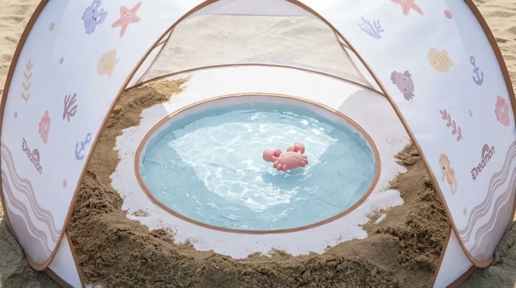 The built-in pool feature of a Dreamon baby tent for beach showing water play.