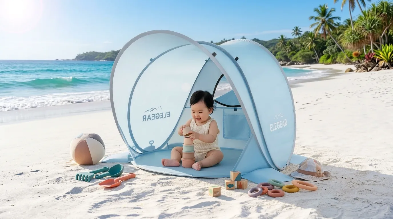 An Elegear beach tent for babies with a mini canopy set up on a sunny beach.
