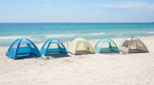 Row of beach camping tents set up side by side on sand for comparison