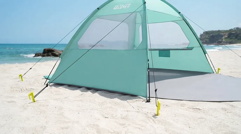 A beach tent secured with stakes and guylines on an exposed coastal bluff