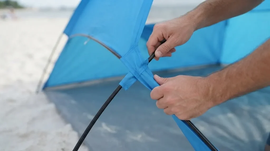 Feeding a fiberglass pole through the sleeve while setting up Camel Crown beach tent