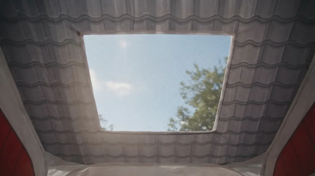 Close up of a diamond shaped mesh roof vent on a red barn farm play tent
