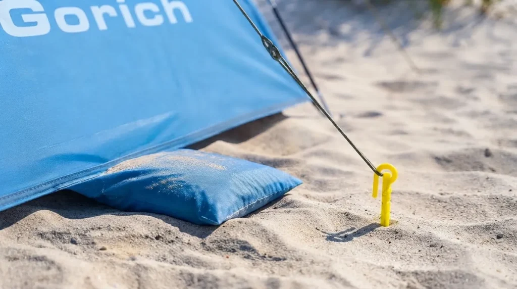Sandbag pocket and ground stake anchoring Gorich beach tent against wind
