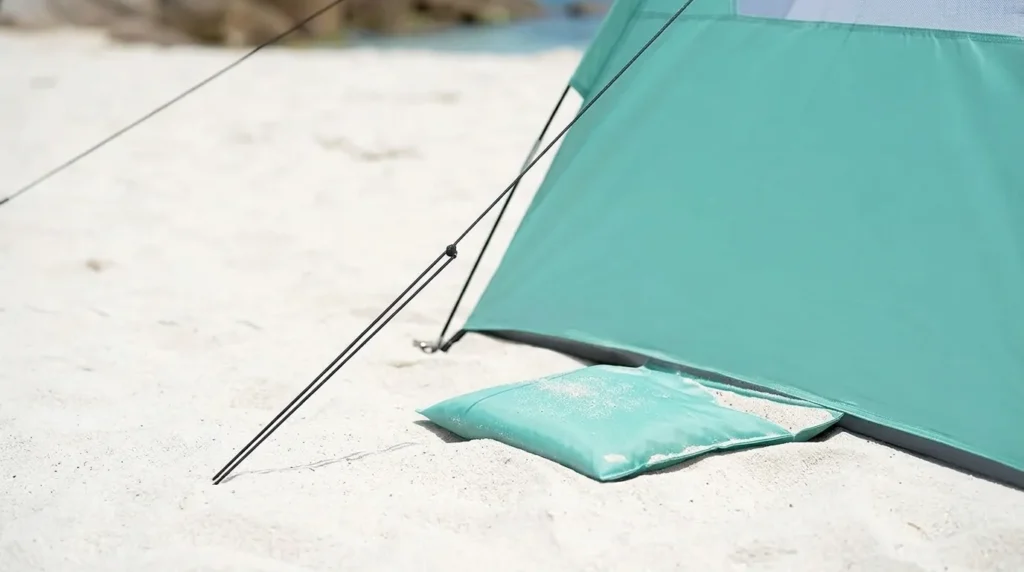 Sturdy buckle and sandbag anchoring a beach tent against wind