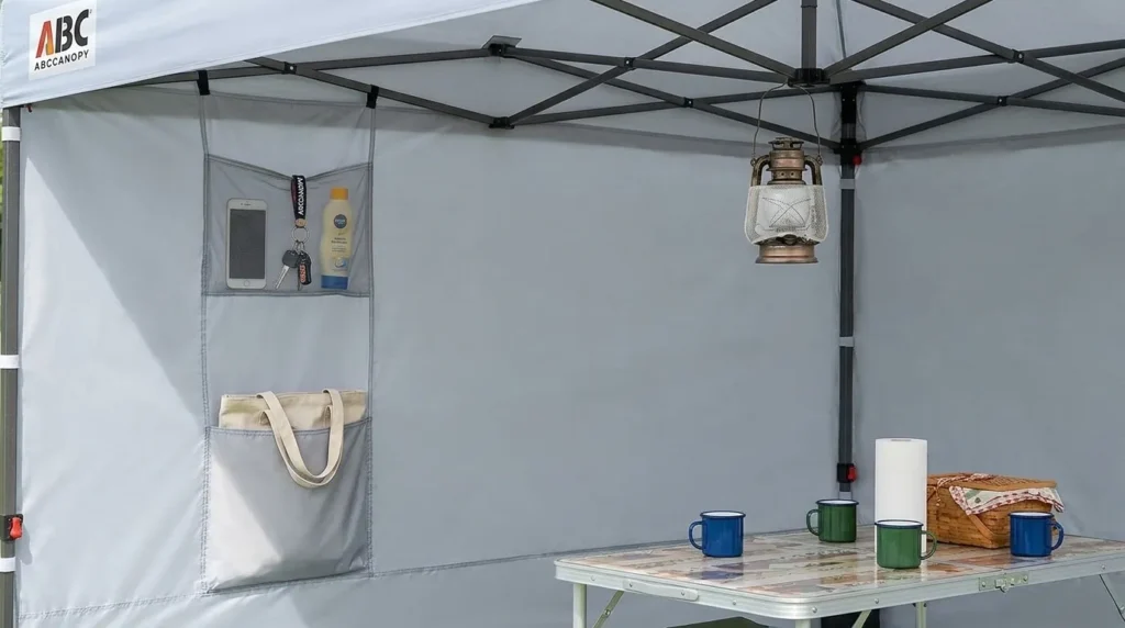 Storage sidewall pockets on an ABCCANOPY pop up canopy tent holding a lantern and small gear