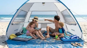 Family sitting inside an EchoSmile pop up tent on the sand