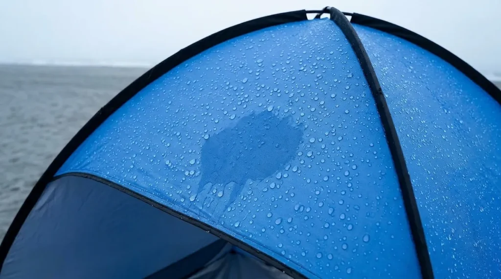 Testing water resistance on a Glymnis pop up beach tent in light rain